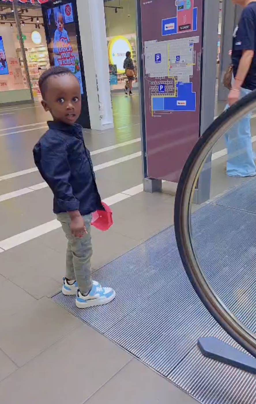 Ethan Rurangwa on a shopping centre walkway, looking back over his shoulder